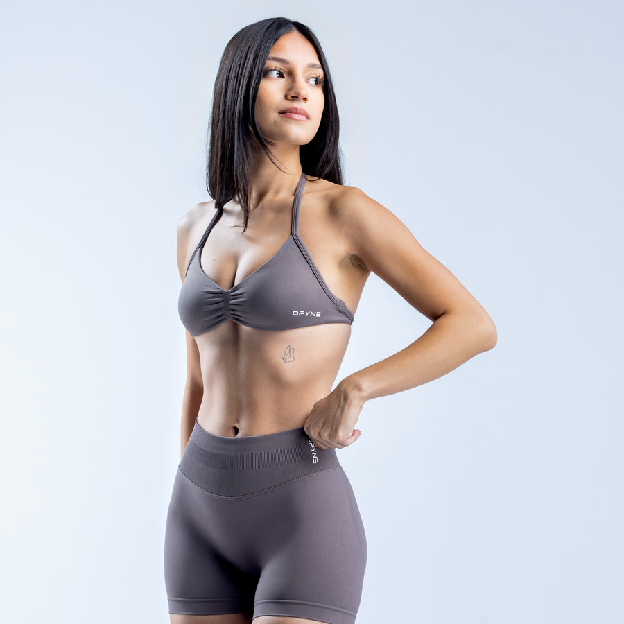 Gray strappy sports bra with twist-front cups and adjustable halter straps