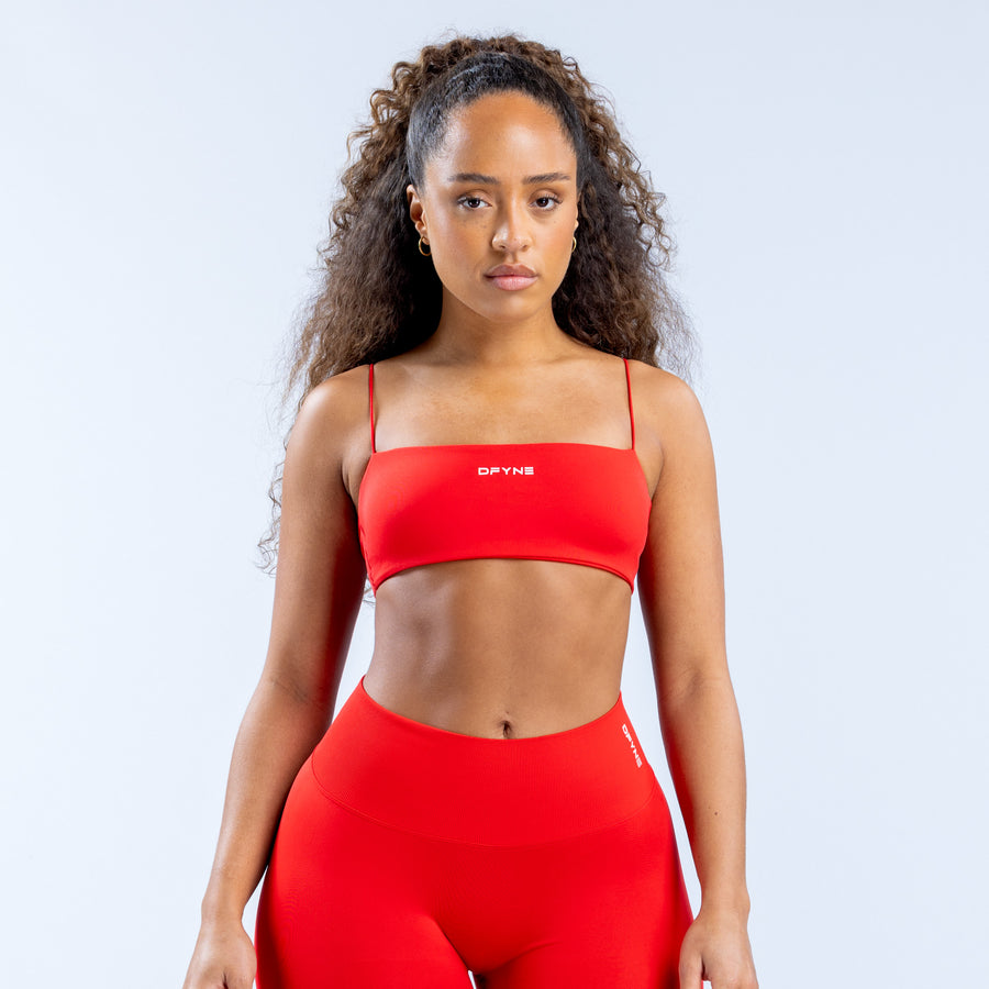 Red strappy sports bra with wide underband and adjustable shoulder straps