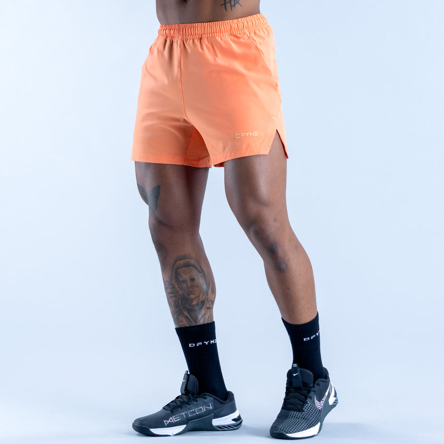 Peach orange training shorts with elastic waistband and side slit