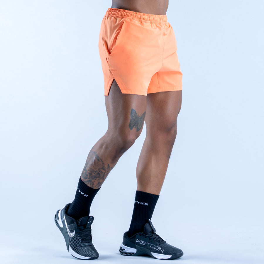 Peach orange training shorts with elastic waistband and rear slit