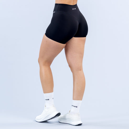 Women's black 4.5" biker shorts, side view, smooth compression fabric and logo accents