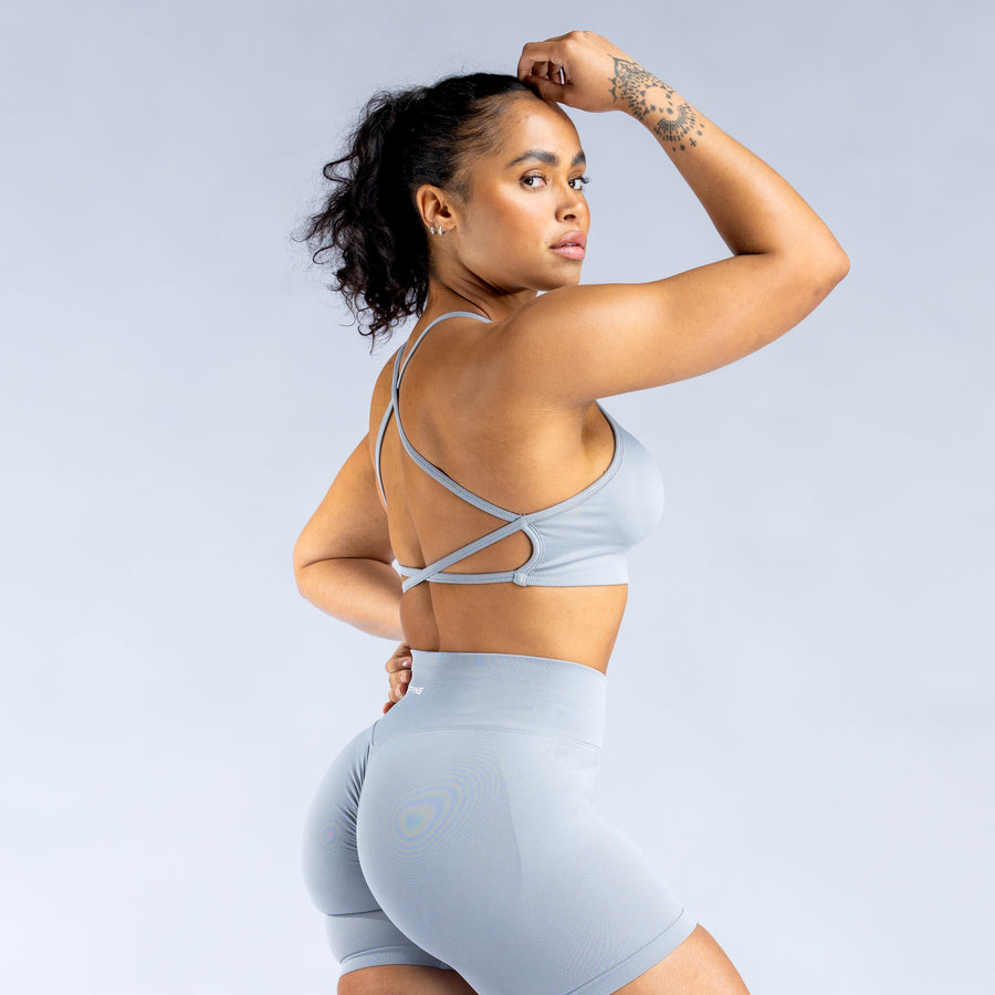 Light blue backless sports bra with thin crossed straps and racer back