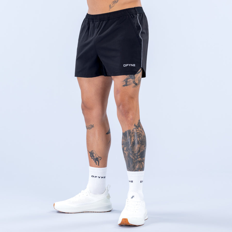 Black 4-inch training shorts with side piping and drawstring waistband