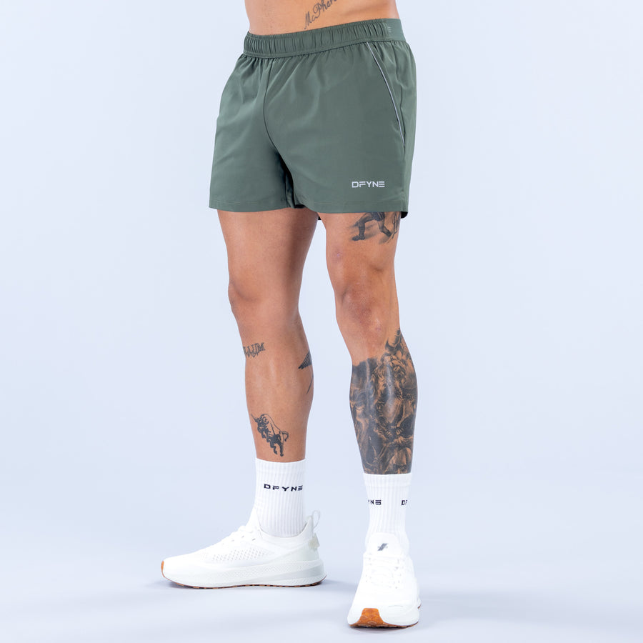 Dark green 4-inch training shorts with elastic waistband and side logo
