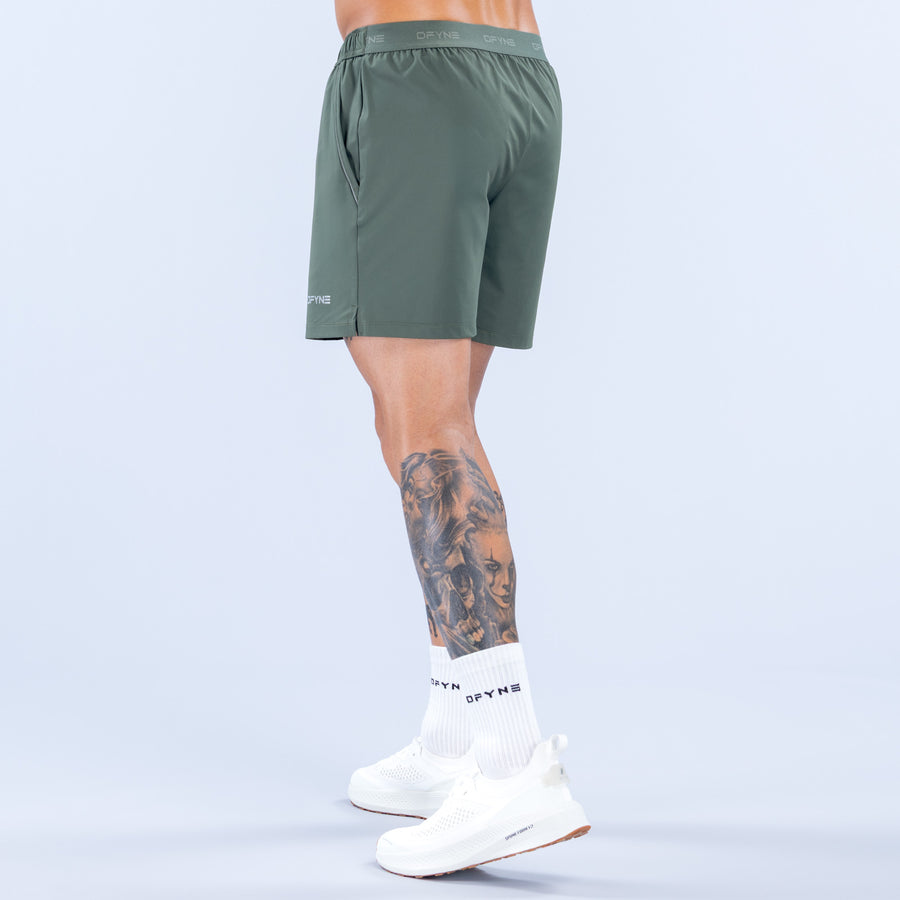 Training shorts for men, dark green, elastic waistband, back view, small logo