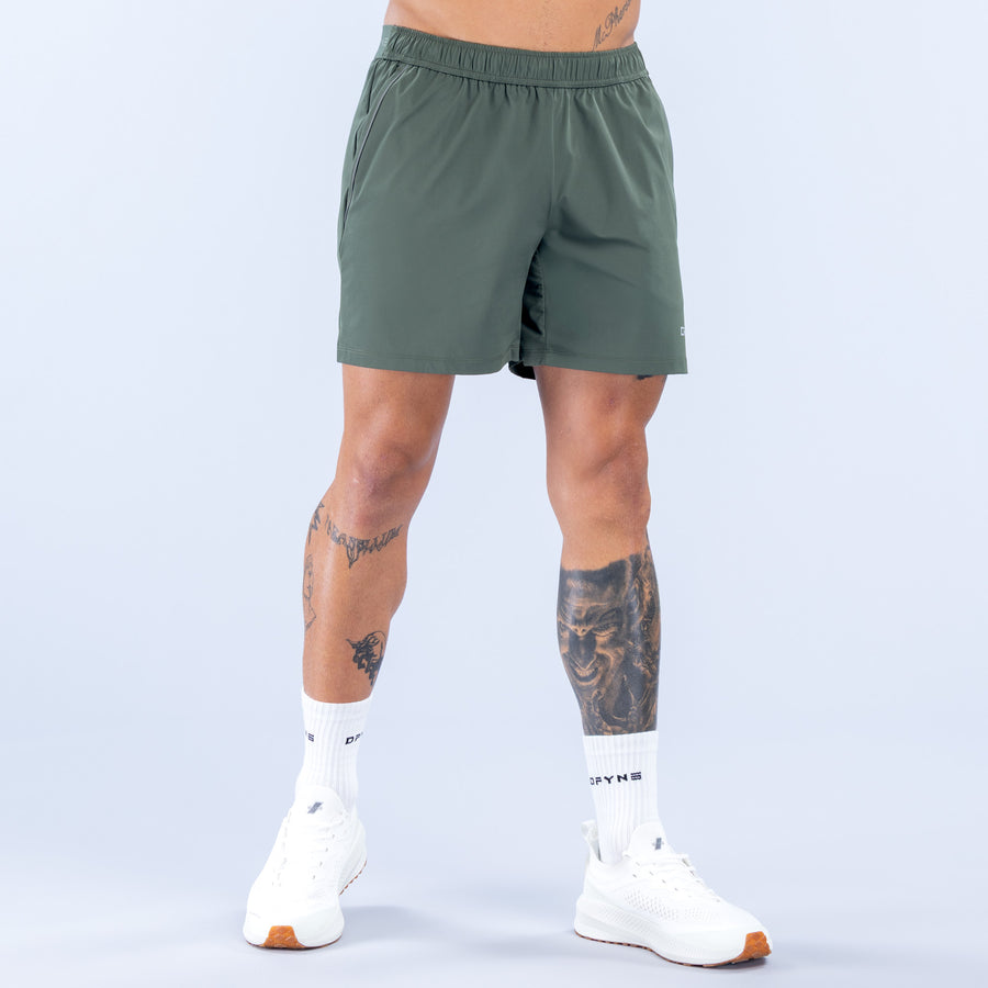 Training shorts for men, dark green, elastic waistband, front view, side logo