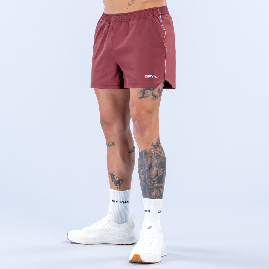 Burgundy 4-inch training shorts with elastic waistband and front drawstring, logo at front
