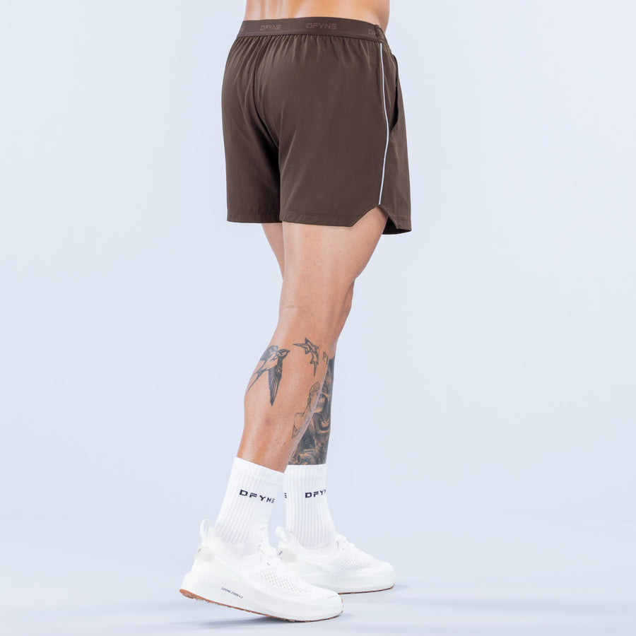 Brown training shorts with elastic waistband and white piping along sides