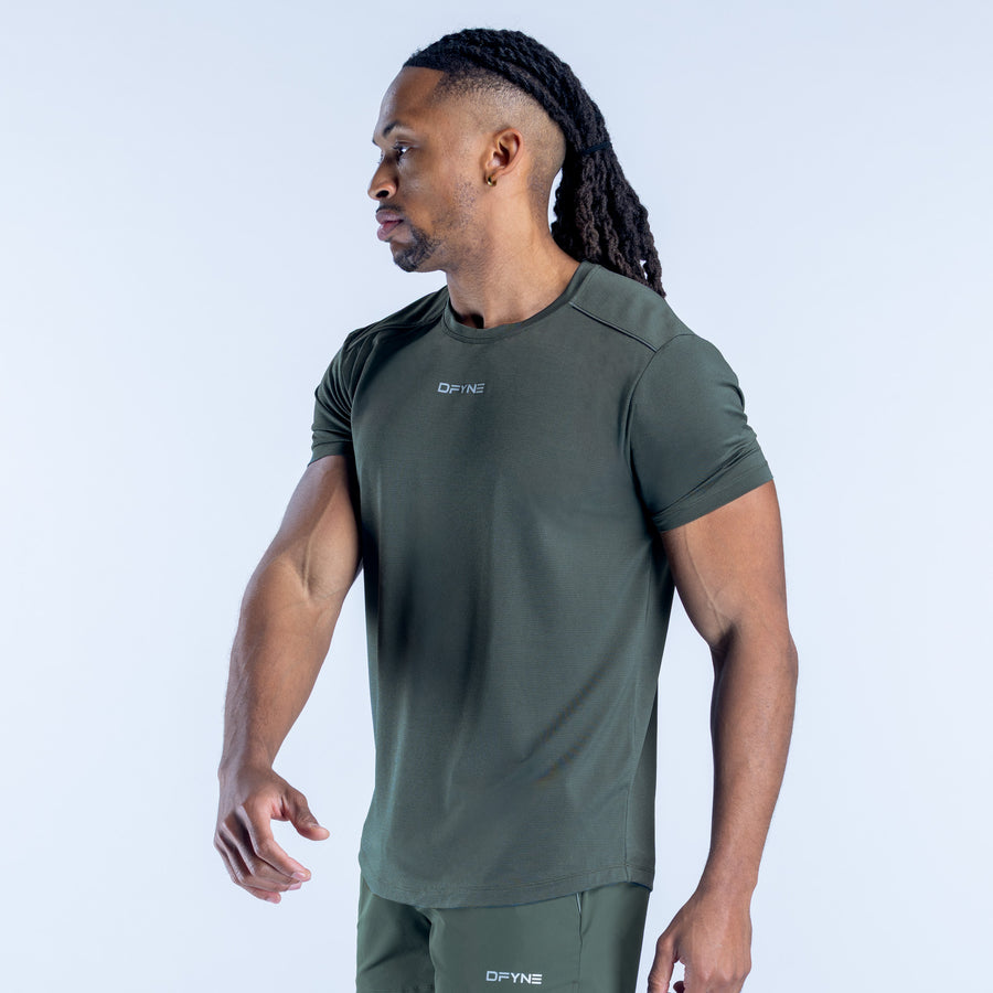 Men's dark green active short-sleeve top, side view showing relaxed fit