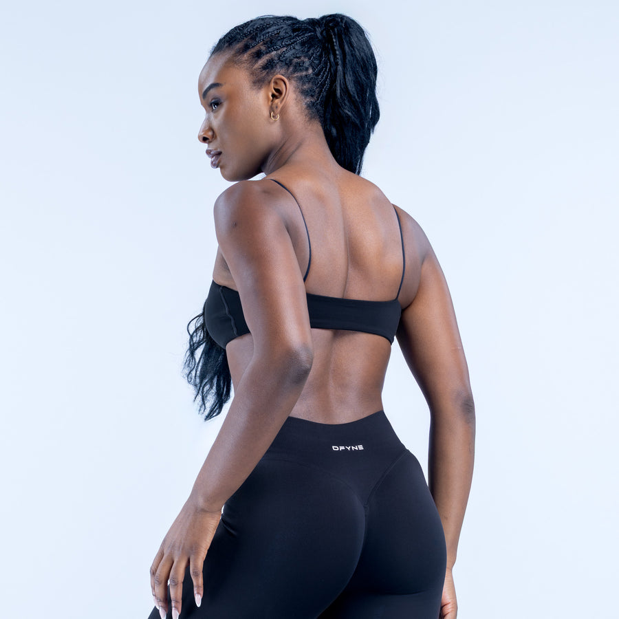 Black strappy bra with open back, thin spaghetti straps, and small logo band