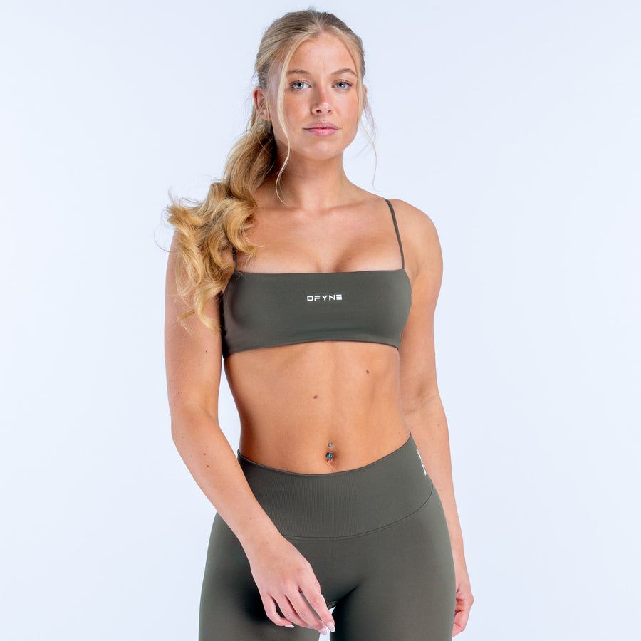Dark green strappy sports bra with center logo band and slim shoulder straps