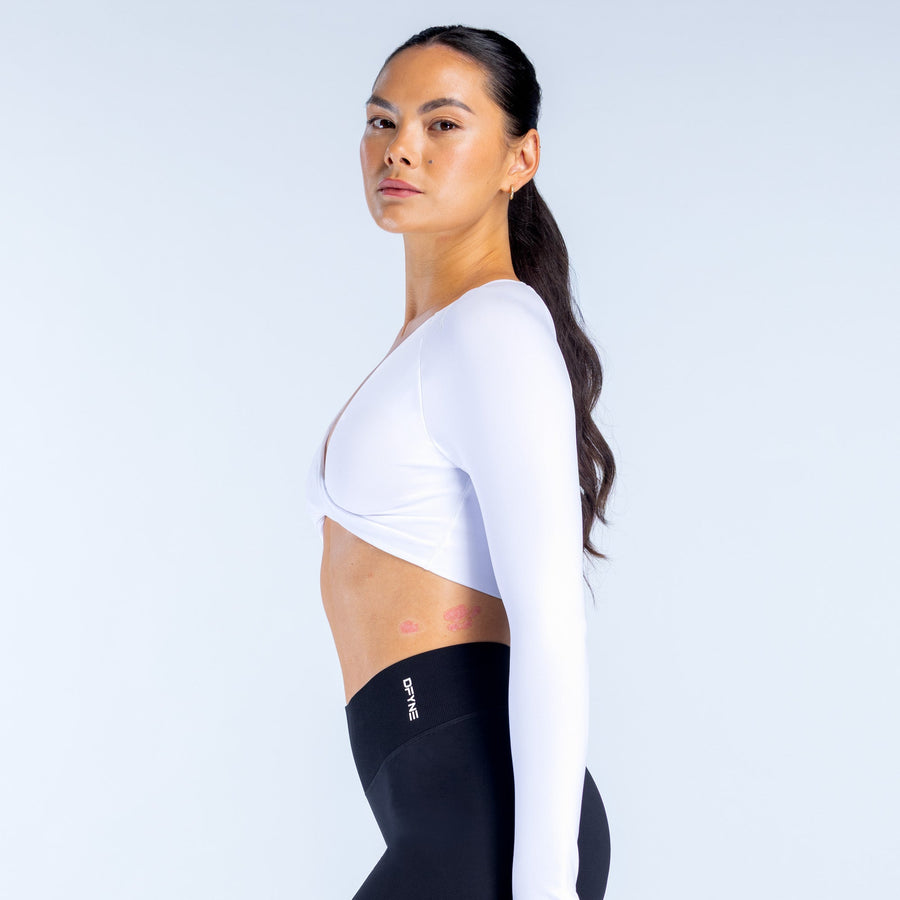 White long-sleeve twist-front V-neck sports top in side profile with cropped length