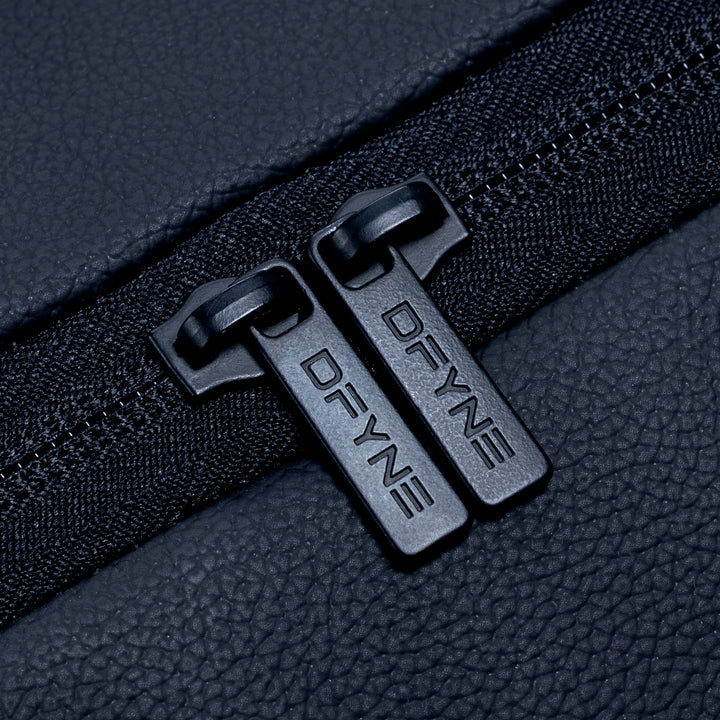 Duffle bag zipper pulls with two black D-rings on dark textured fabric