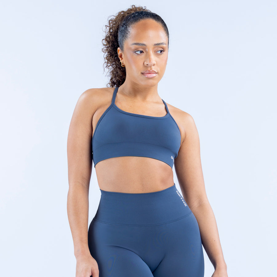 Navy backless sports bra with racerback-style front straps and logo