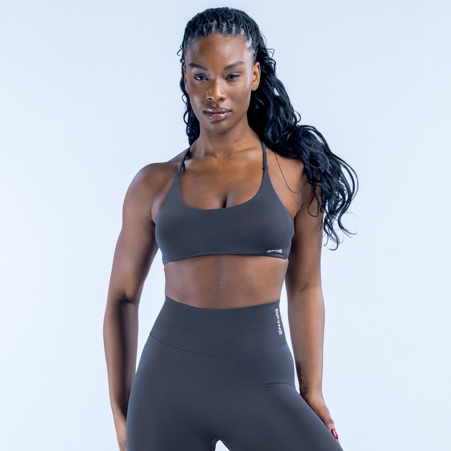 Sports bra with thin straps and small logo, dark gray front view
