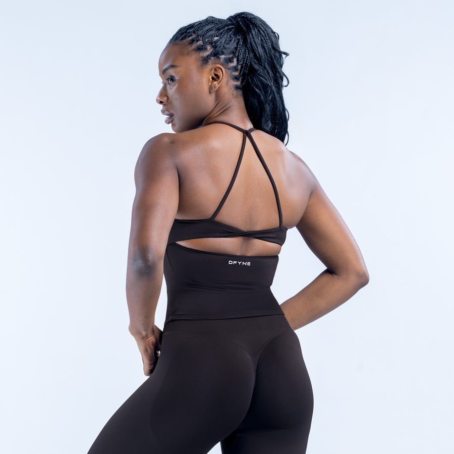 Black open-back sports top with thin crossed straps and lower back twist