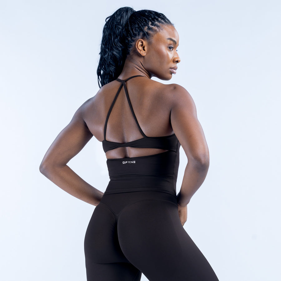 Black sports top with crossed back straps and twist detail near neckline