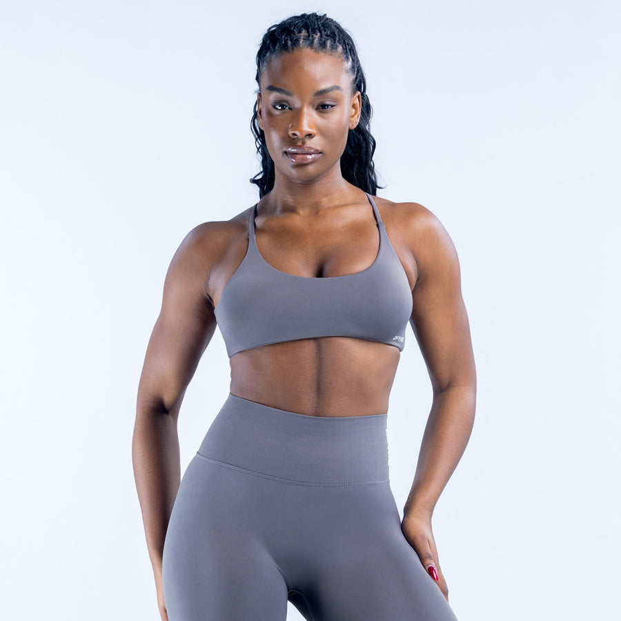 Twist-back sports bra in dark gray with front scoop neckline and smooth molded cups