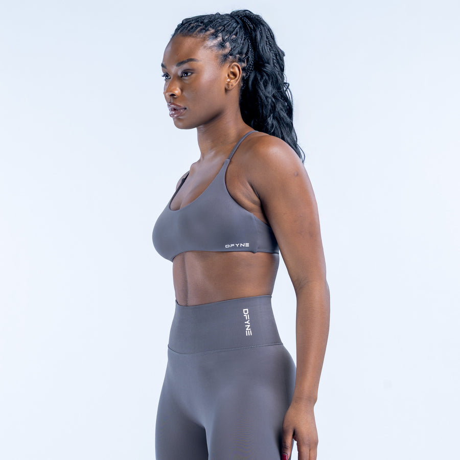 Twist-back sports bra in dark gray with racerback straps and smooth underband