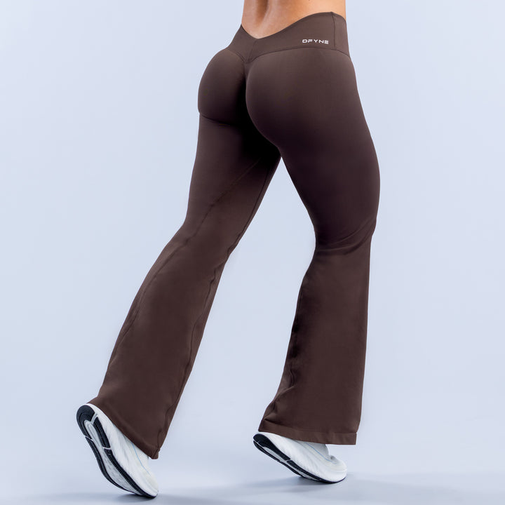 Dark brown bell-bottom style leggings with tapered waistband and smooth finish