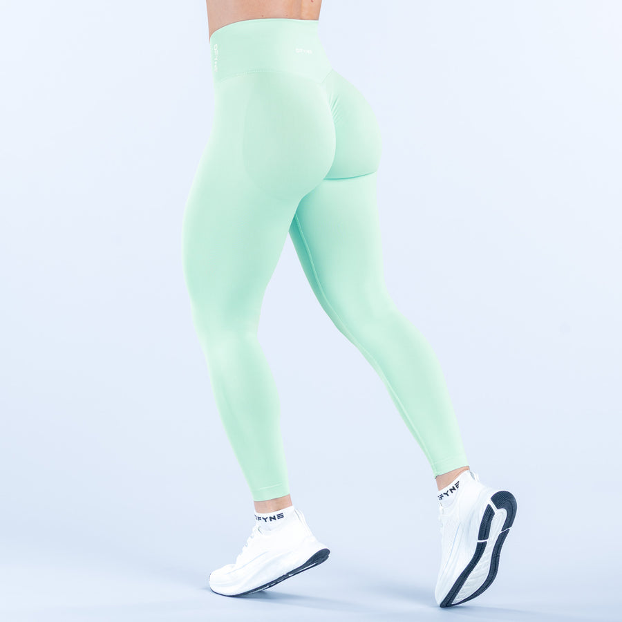 Mint green leggings, side view, smooth stretch fabric with stitched seams.