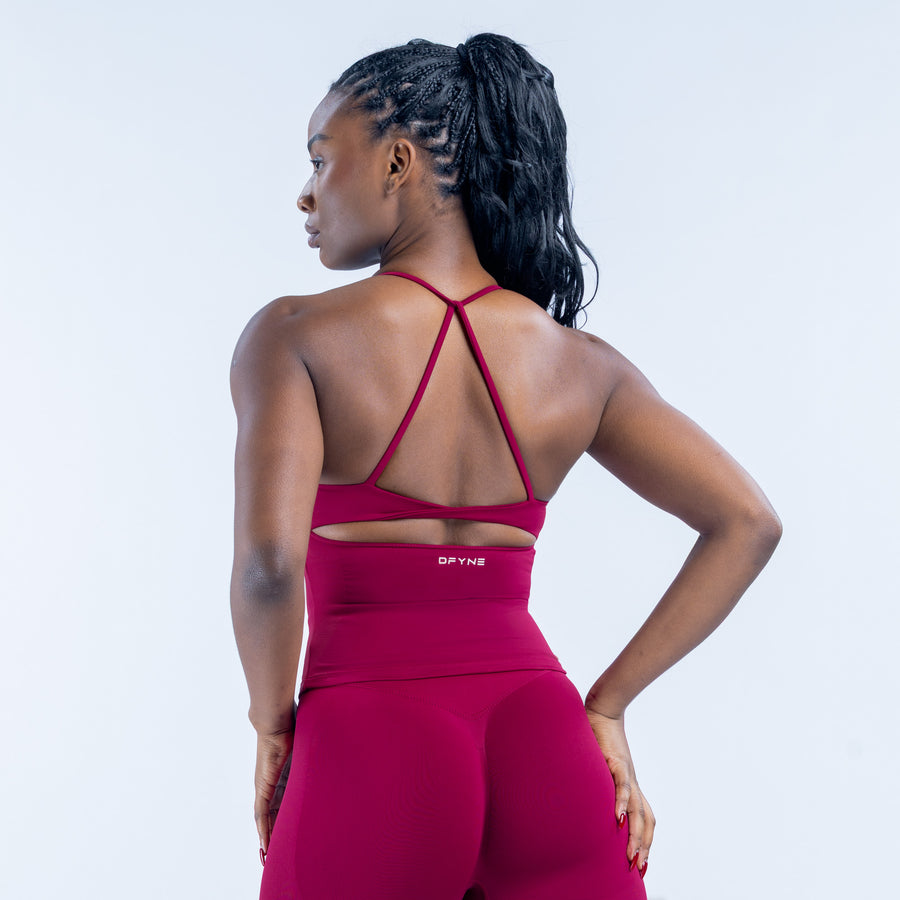 Magenta sports top with crisscross open-back straps and racer neck