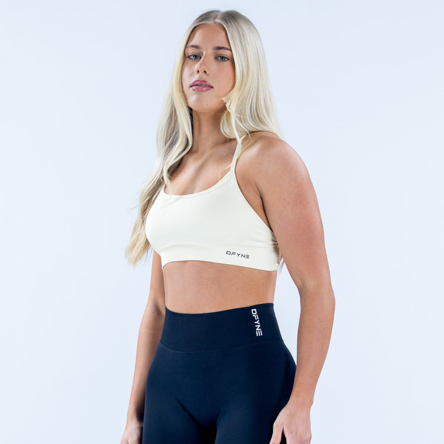 White backless sports bra with thin straps and racerback cutout, DPYNB logo