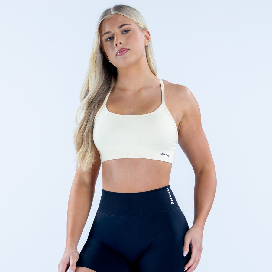 White sports bra with thin straps and backless racerback cutout, DPYNB logo