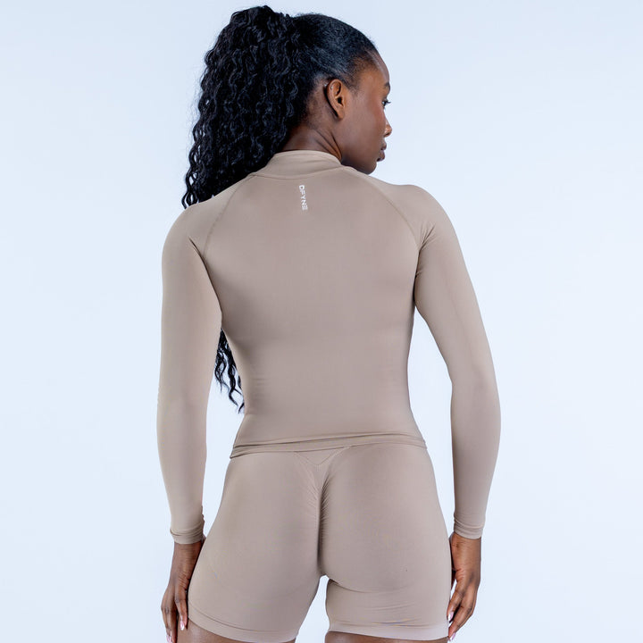 Women's taupe zip-front athletic jumpsuit, back view with long sleeves