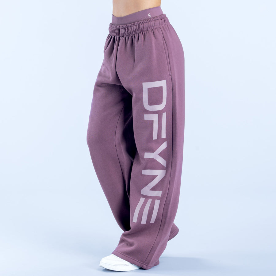 Purple wide-leg jogger pants with elastic waistband and bold vertical logo detail