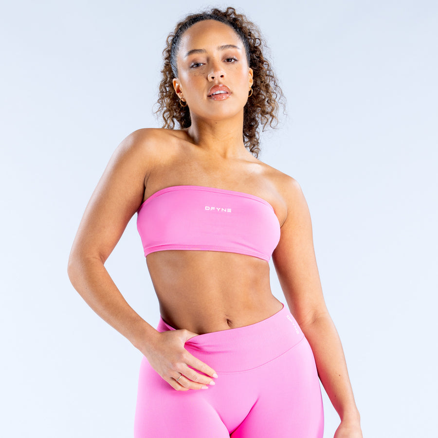 Pink strapless bandeau top with small logo at center chest