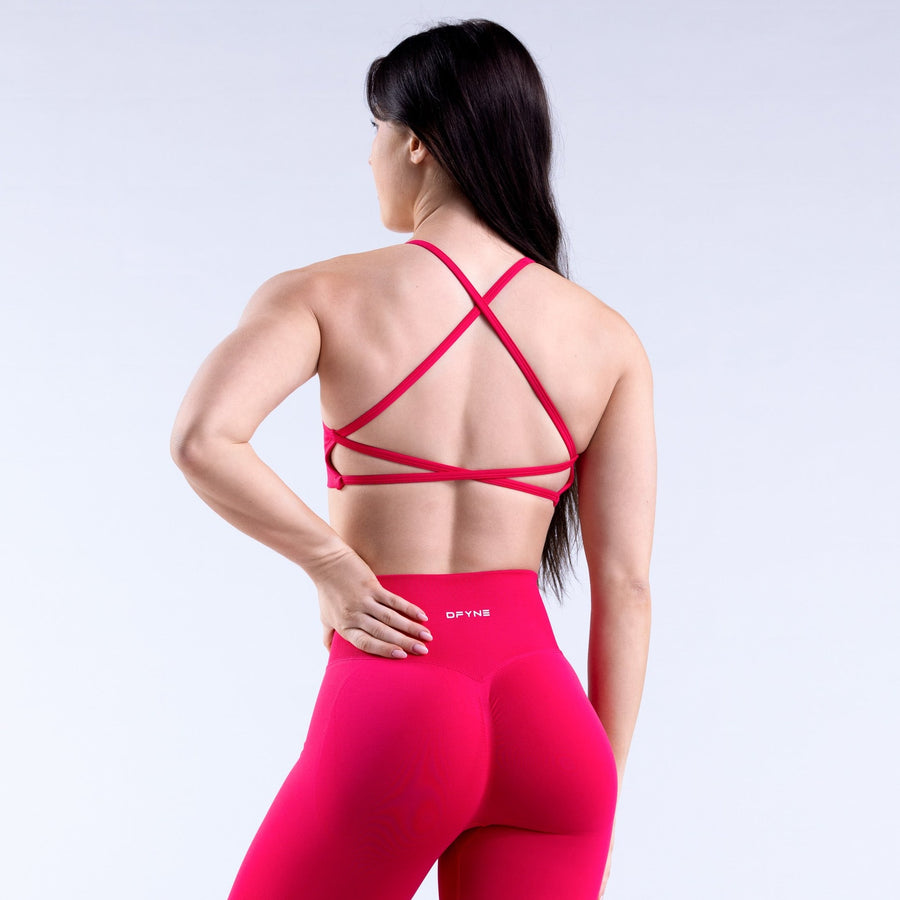 Magenta open-back sports bra with crisscross straps across the back