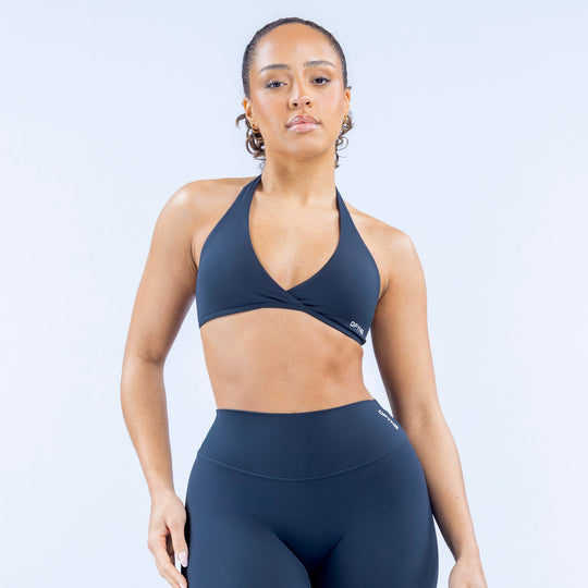Dark blue halter sports bra with V neckline and front twist detail
