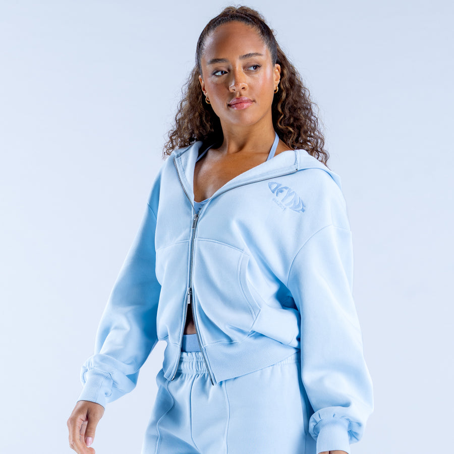 Light blue zip-up hoodie with hood and small chest graphic on left side