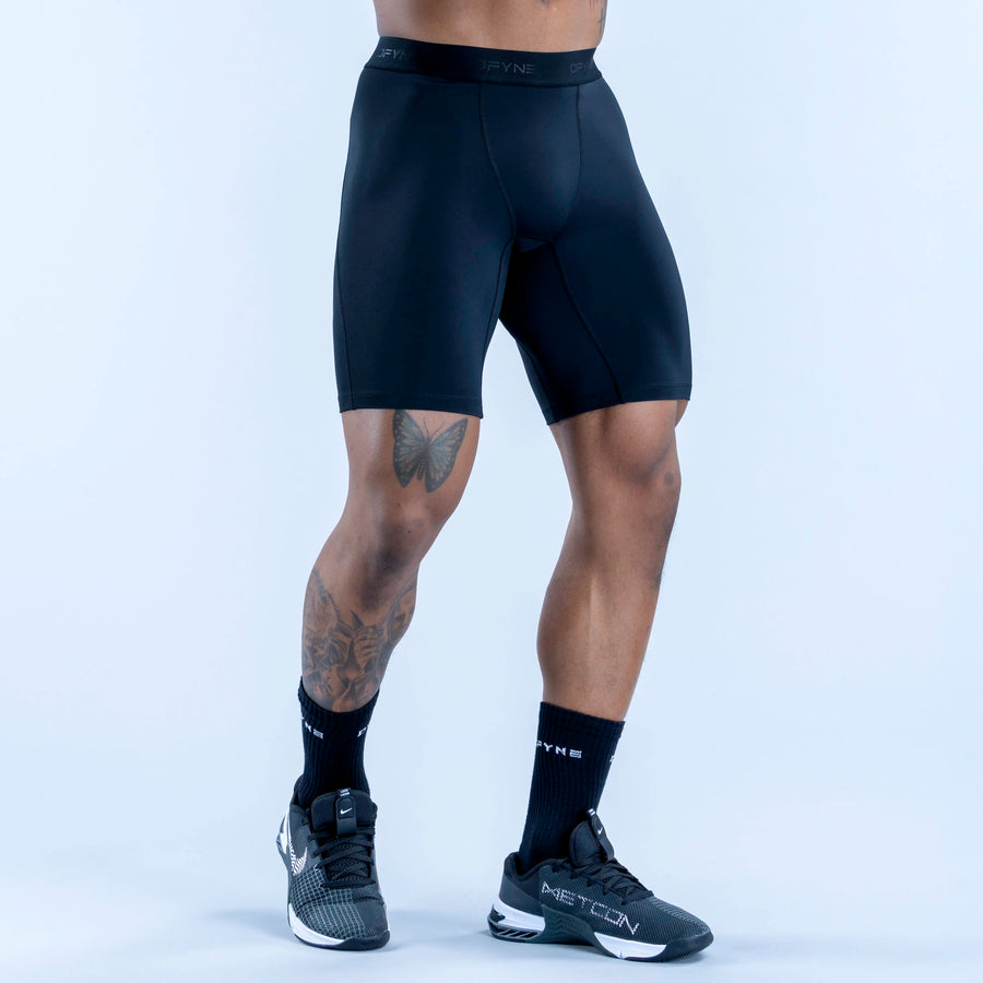 Dark blue compression baselayer shorts, mid-thigh, contoured panels, elastic waist