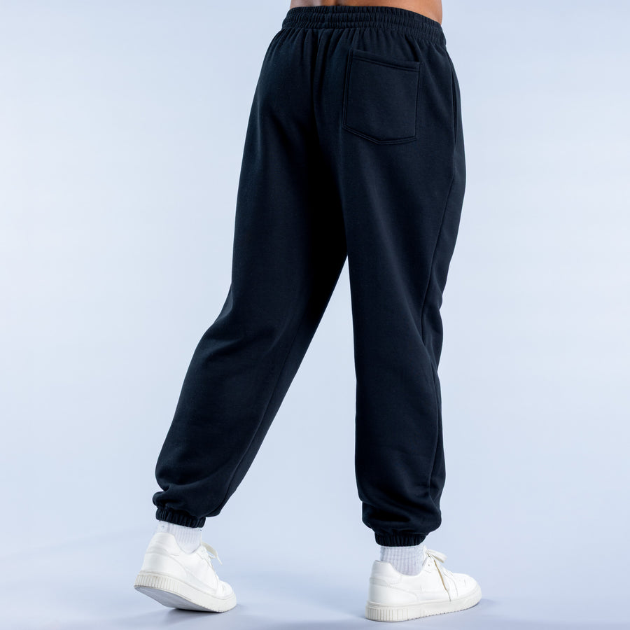 Black cuffed jogger pants from back with pocket detail and elastic hem cuffs