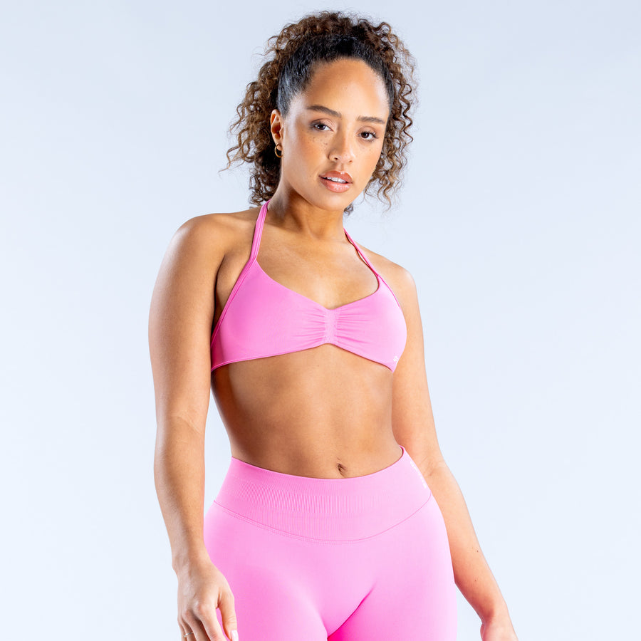 Pink strappy sports bra with V neckline and gathered center
