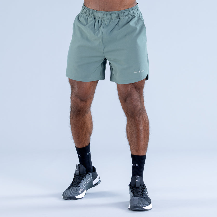 Light teal training shorts with elastic waistband and front pocket openings