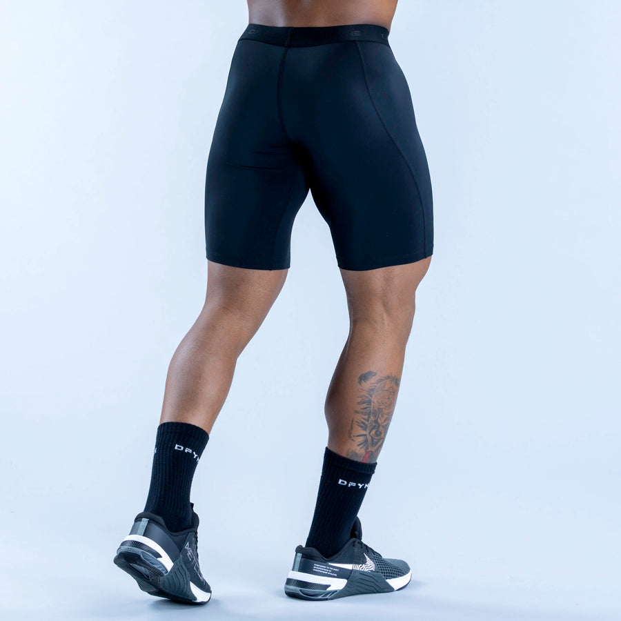 Dark blue compression baselayer shorts with smooth contour seams, mid-thigh, logo