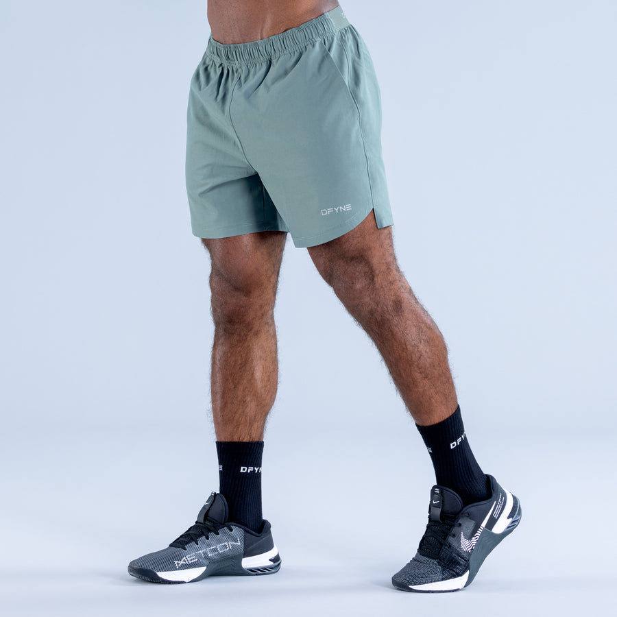 Light teal training shorts with elastic waistband, side pockets, and logo