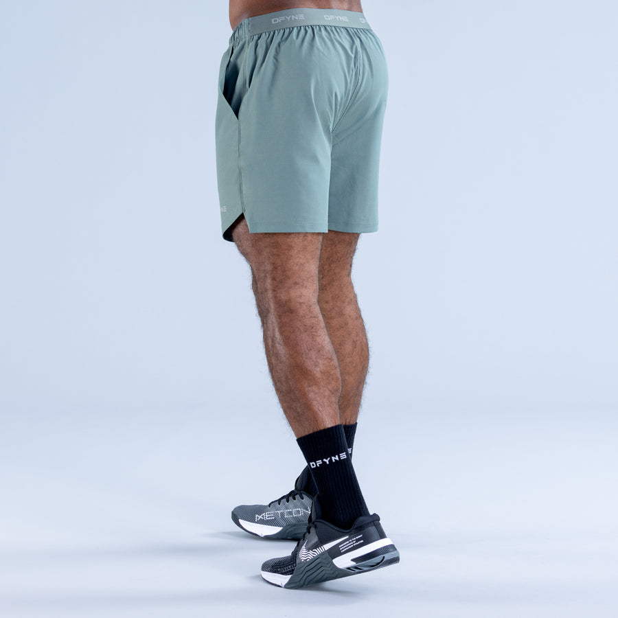 Light teal training shorts with elastic waistband and side pockets