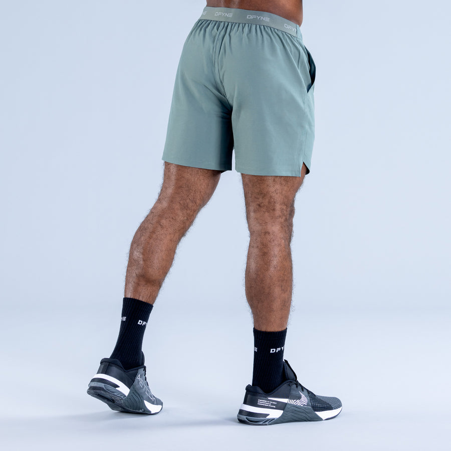 Light teal training shorts with elastic waistband and relaxed straight legs