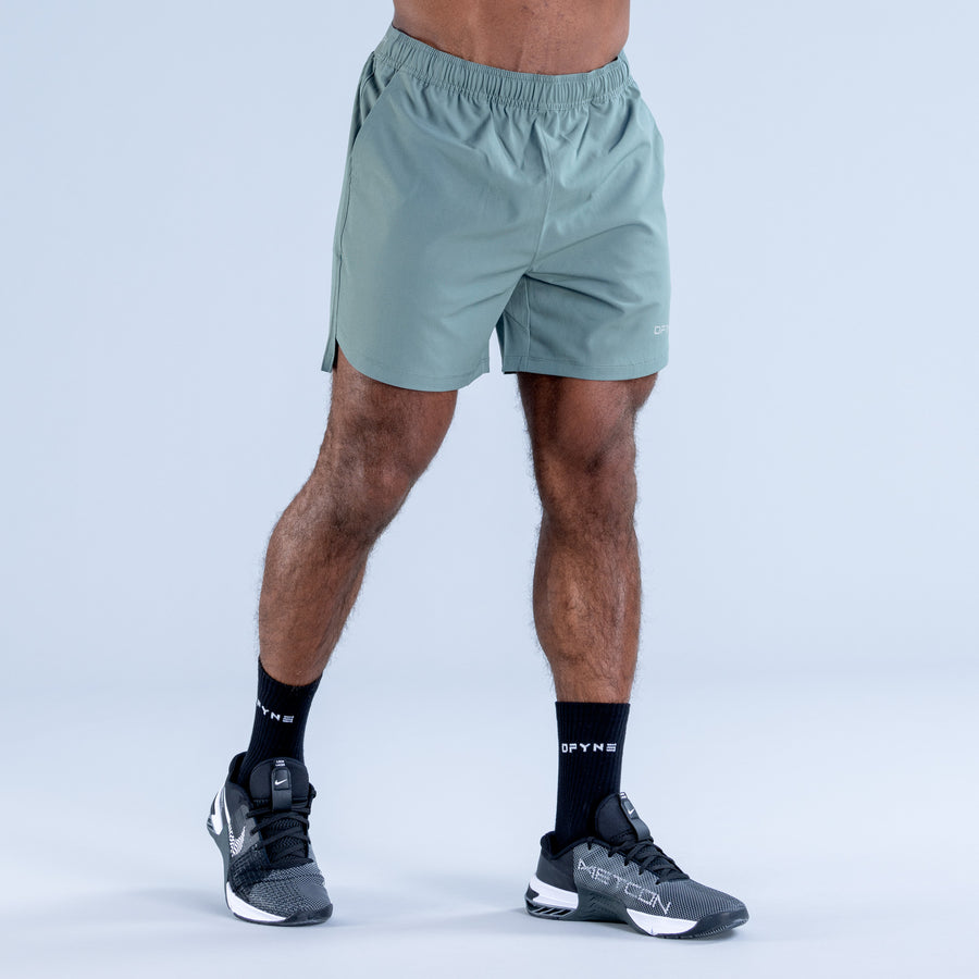 Light teal training shorts with gathered elastic waistband and small logo