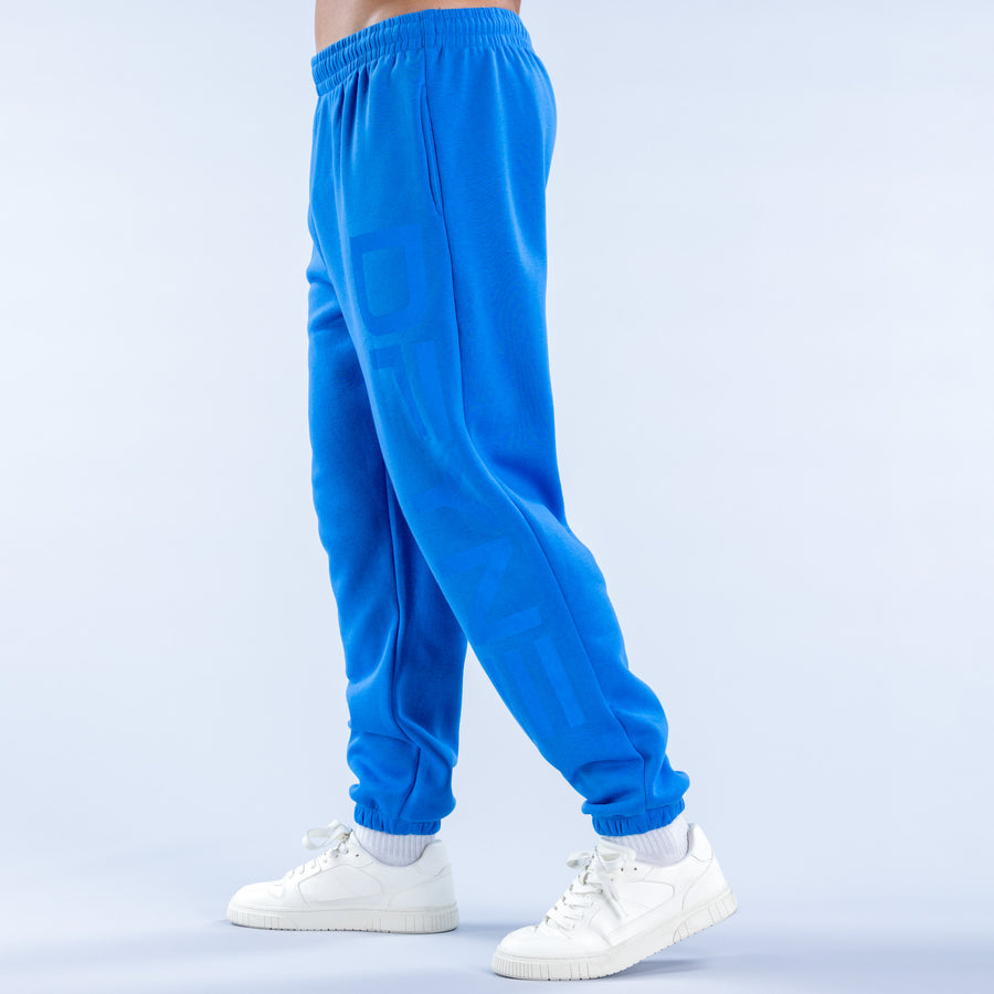 Blue cuffed jogger pants with elastic waistband, side seams, and printed leg detail.