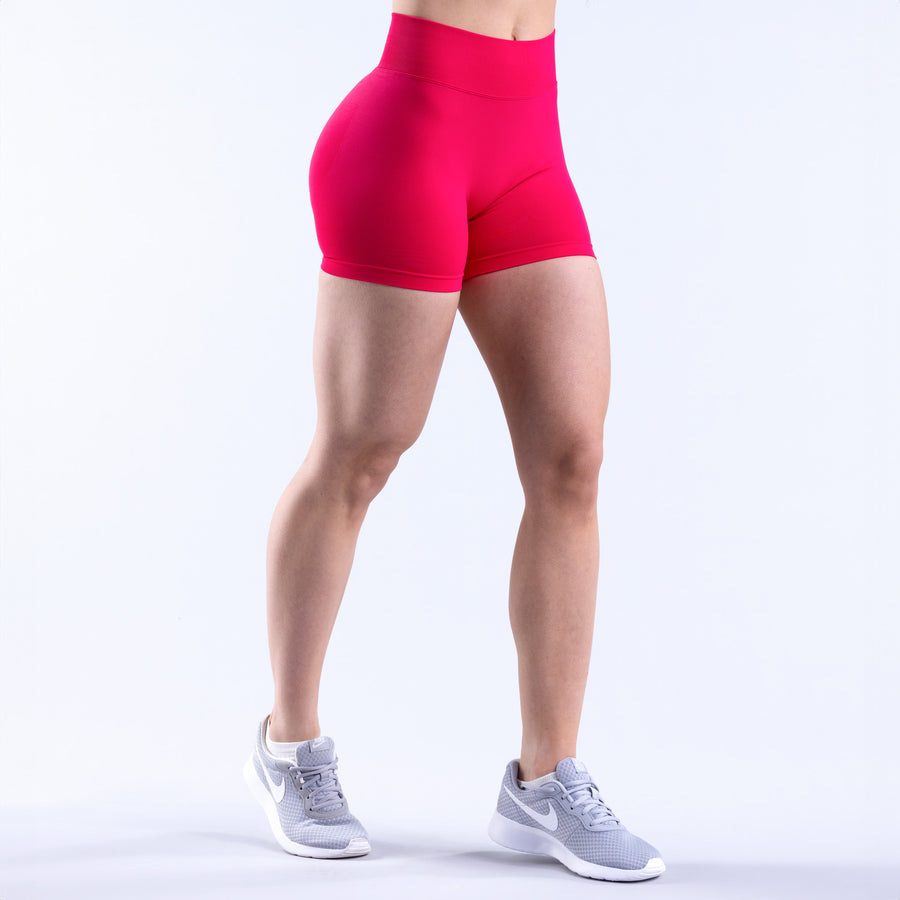 Fuchsia athletic shorts in side view with curved seam detailing