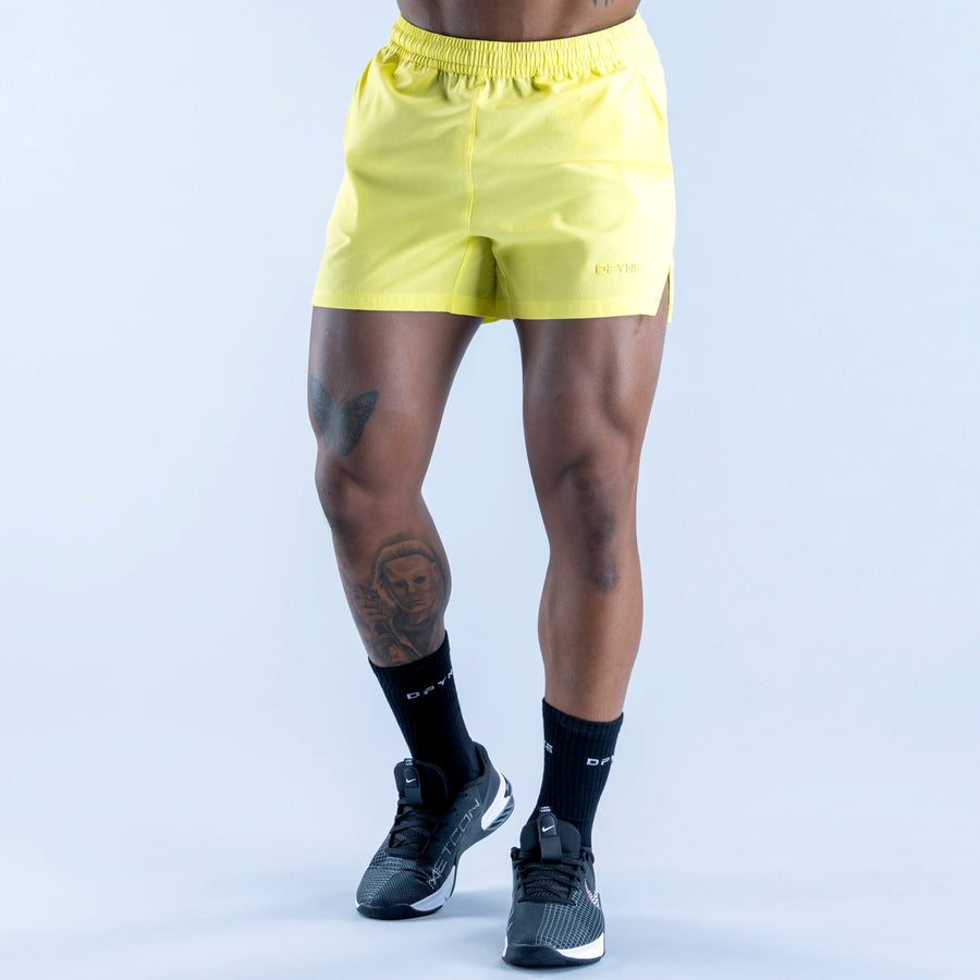 Lime yellow training shorts with elastic waistband and relaxed fit