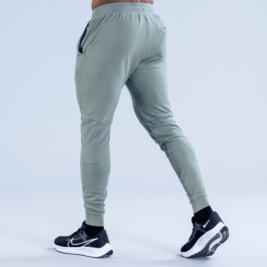 Sage green tapered jogger pants from back, elastic waistband and elastic cuffs