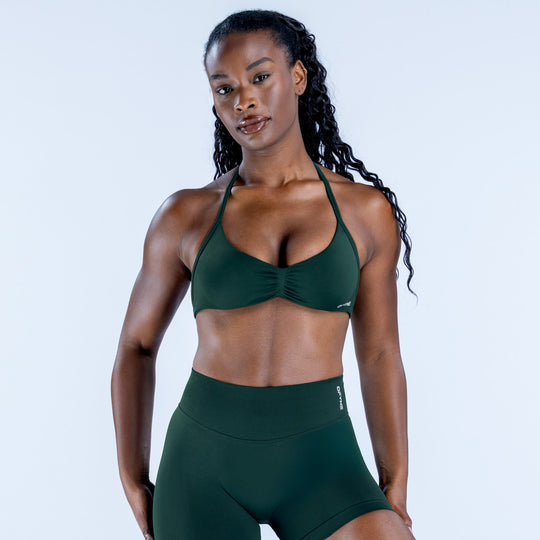 Impact strappy bra in dark green, front view with scoop neckline and molded cups