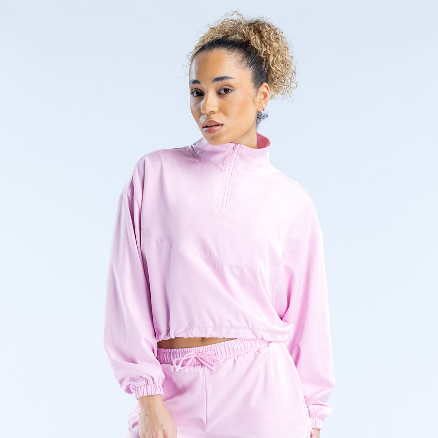 Light pink cropped zip jacket with high collar, front zipper, and drawcord hem