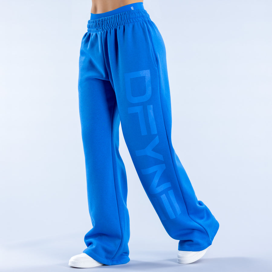Blue wide-leg joggers with elastic waistband, cuffed hems, and large front graphic